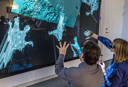 Two persons in front of a visualisation screen.