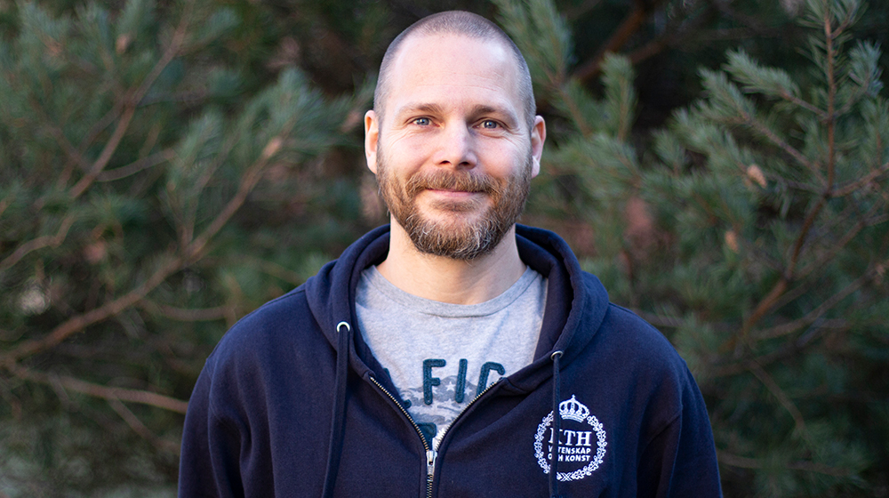 Portrait of Mikael Ersson in front of a tree.