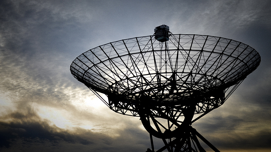 rund satellitmottagare mot kvällshimmel