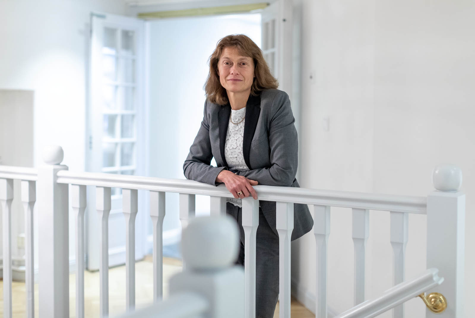 Sara Mazur står framför ett vitt räcke inomhus