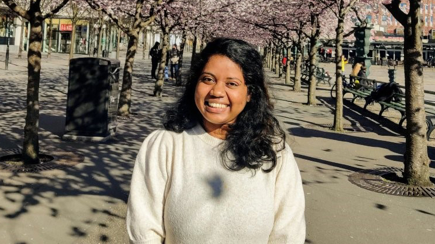 Aashlesha Chekkala posing in an arcade of cherry trees in Stockholm. 