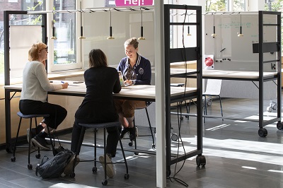 Three people sitting by a table