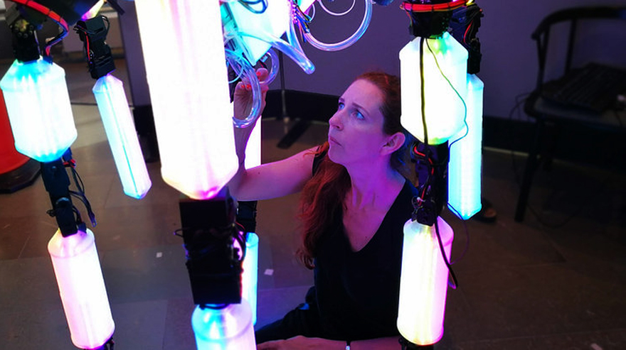 A woman interacting with the robot sculpture.