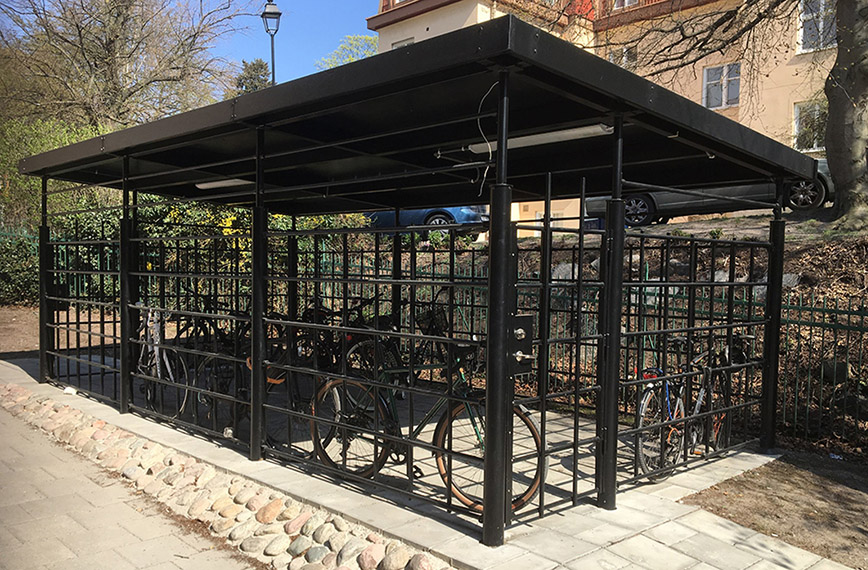 A bicycle shelter built of metal with lattice walls.