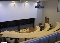Föreläsningssal med successivt upphöjda platser. Tre första rader stolar, resten fasta platser.