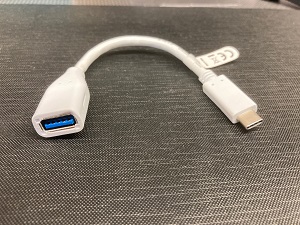 Foto på en USB-C till USB-A adapter i form av en kort kabel.