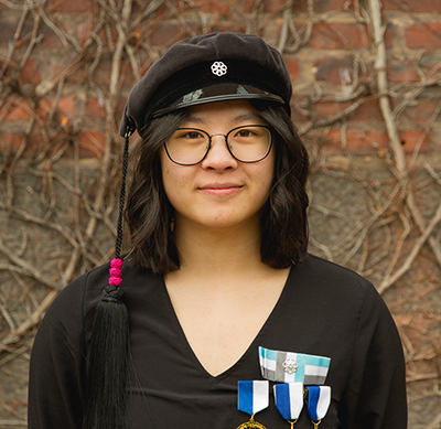 Portrait Photo: A young woman wearing av student hat.