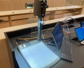 Photo of document camera in a lecture hall, connected to laptop.