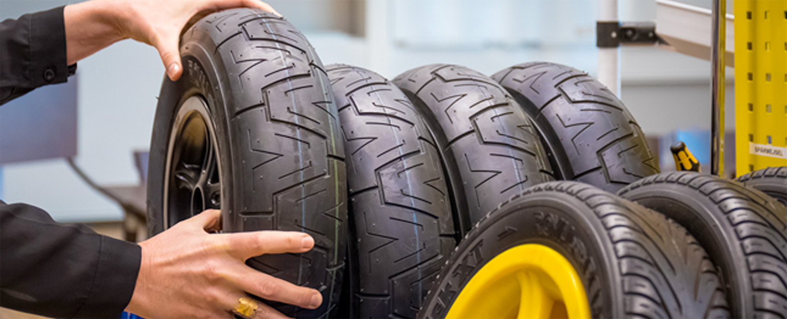 Hands adjusting a pile of tires 
