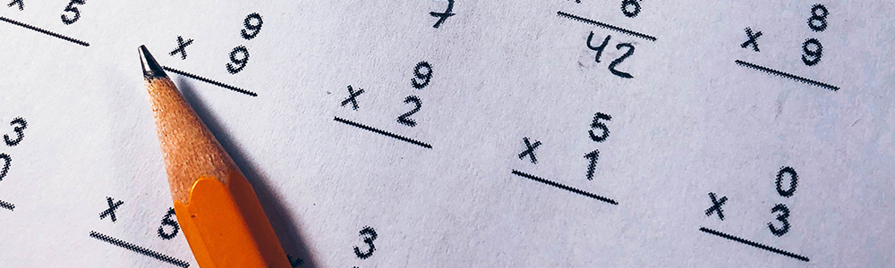 A pencil on paper with math numbers
