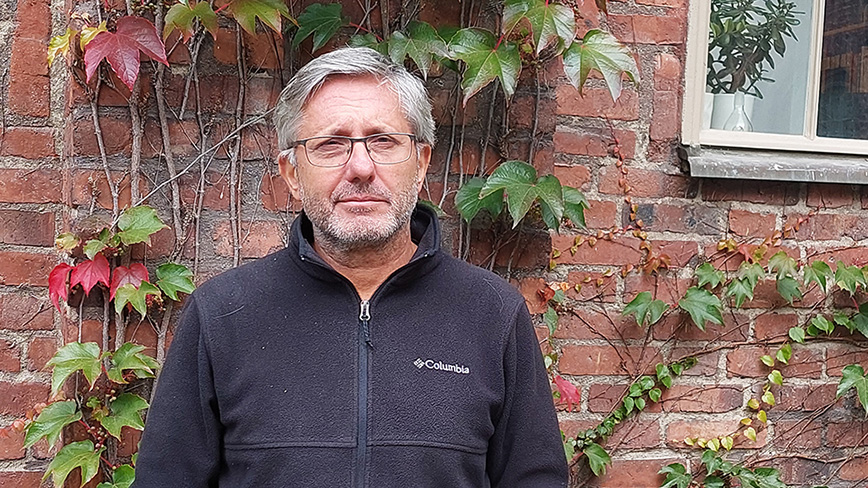 Man in front of brick wall.
