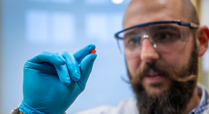 New solar cells showed by a man with blue gloves.