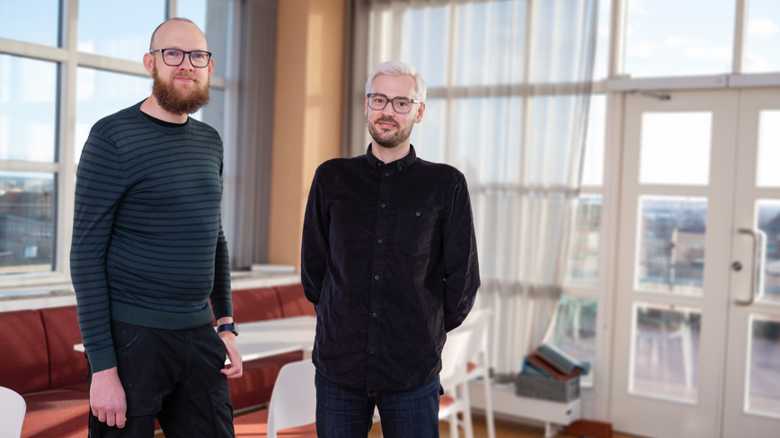 Two men looking into the camera. 