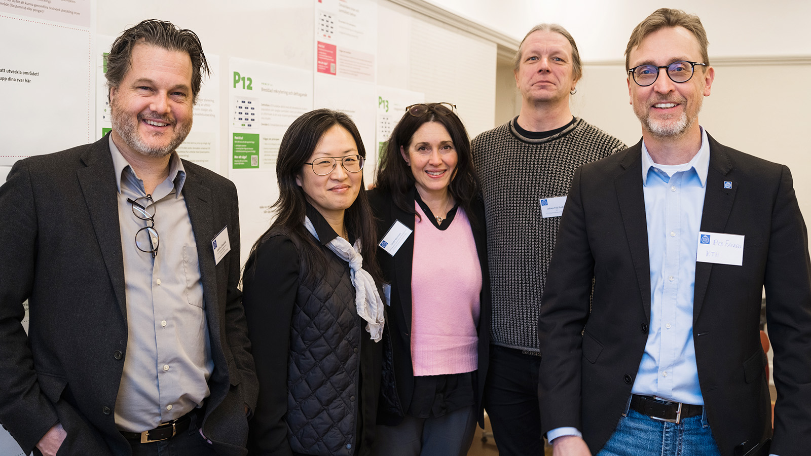 Group photo of two women and three men who are smiling.