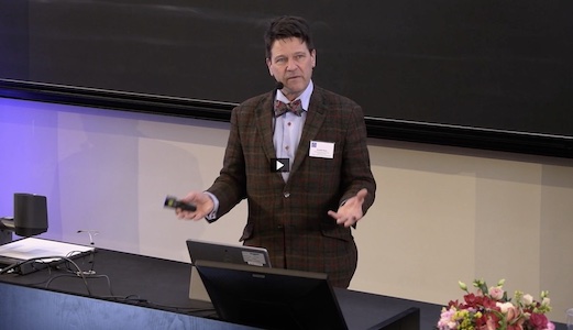 Man i kavaj håller en presentation.