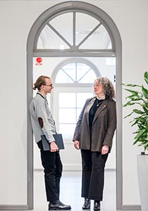 A man and a woman are having a conversation in a doorway.