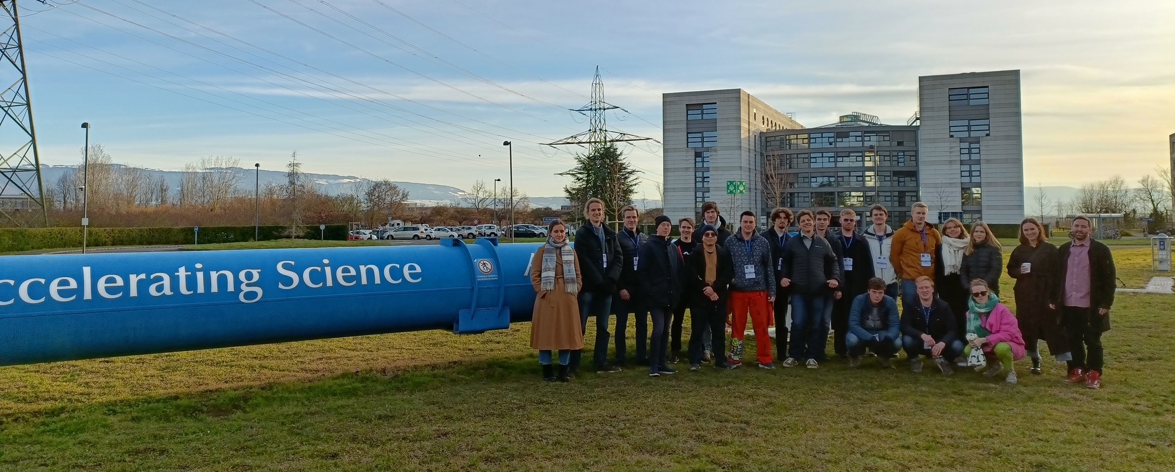 Visitors at CERN in fornt om blue pipe labeled "Accelerating Science".