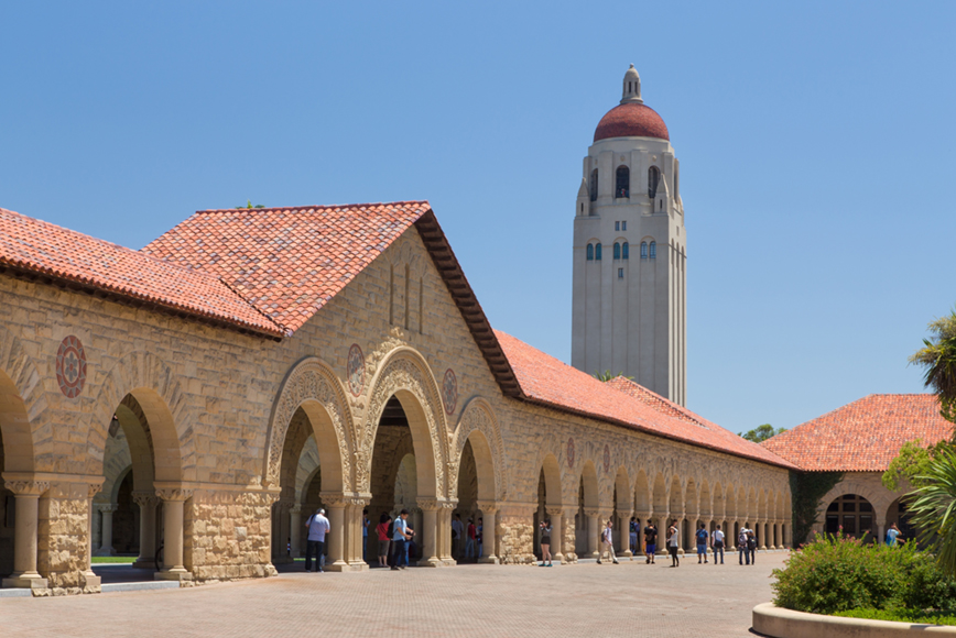 Long narrow building with tower in the background. 