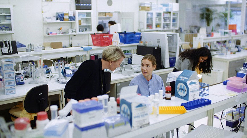 Persons working and talking in a laboratory.