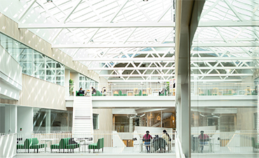 Students in building with glass ceiling.