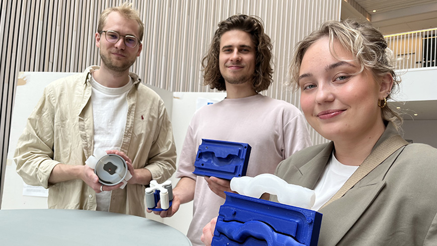  Three students show off the parts for the artificial heart.