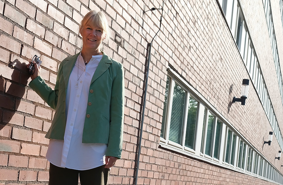 Lena Gumelius stående utanför ett KTH byggnad