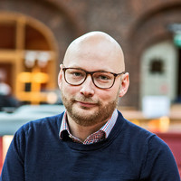 Stefan Stenbom wearing glasses and a navy sweater.