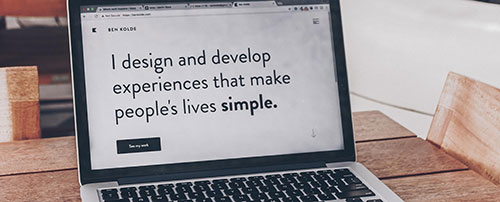 A laptop with the text "I design and develop experiences that make people's lives simple".