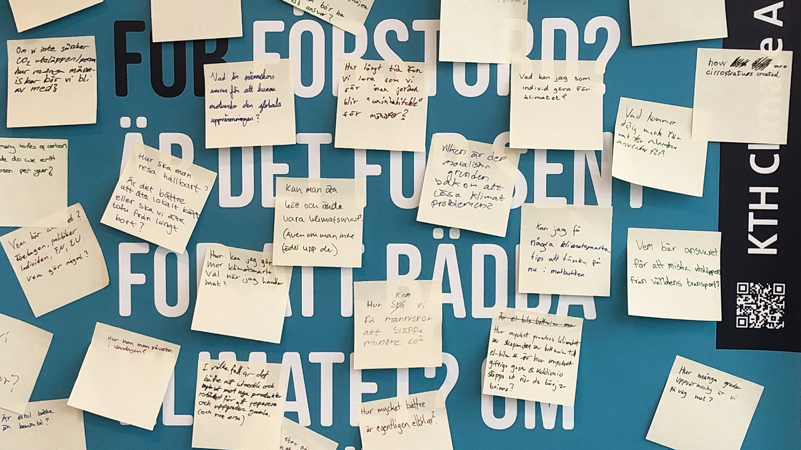 Frågor på post-it lappar som studenter satt upp på väggen. 