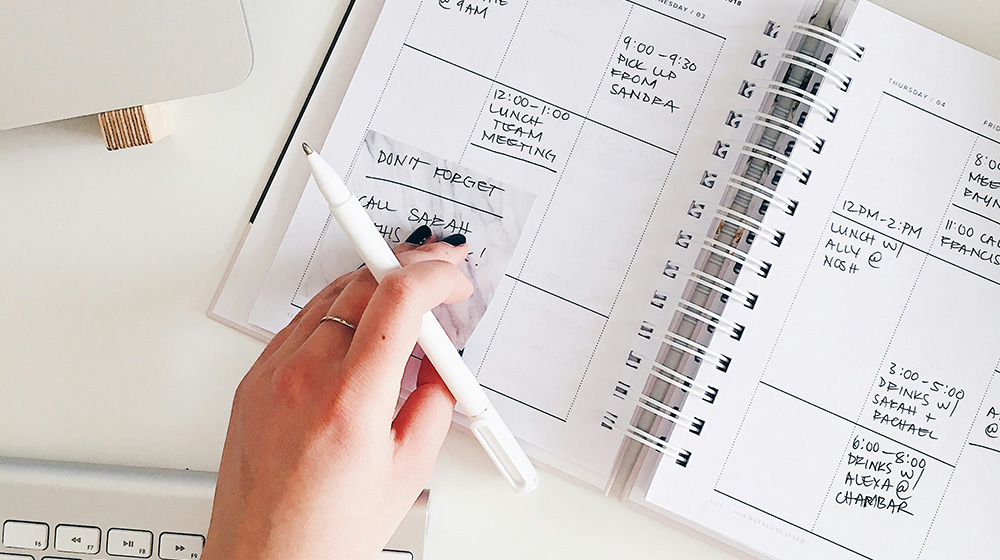 Hand med penna vid kalender