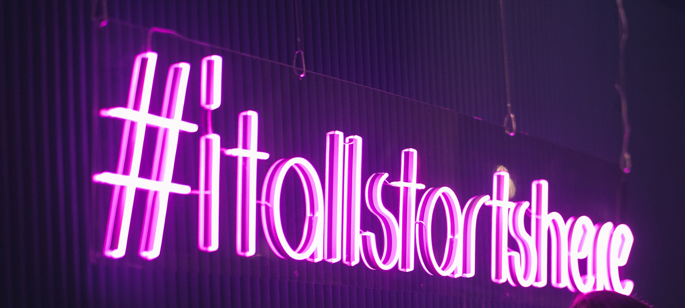Neonskylt med texten #ItAllStartsHere