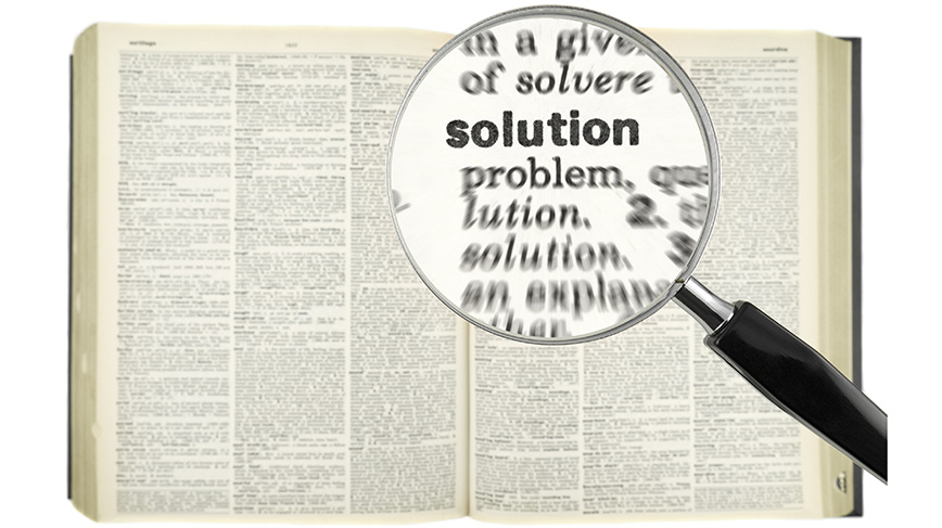 Pointing out the word solution in a dictionary with a magnifier.