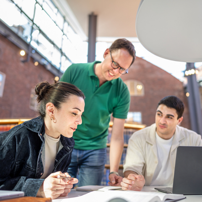 Instructor helping two persons at a table