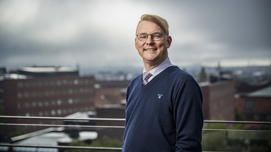 Carl-Niclas Odenbring stående utomhus på en terrass med KTH Campus i bakgrunden.