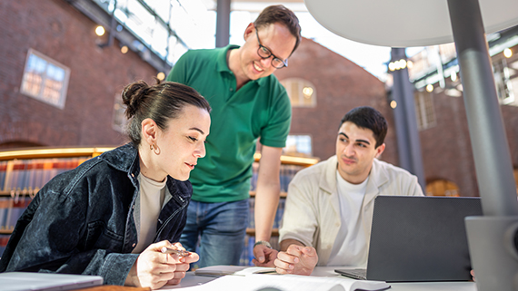 Lärare och studenter i biblioteket.