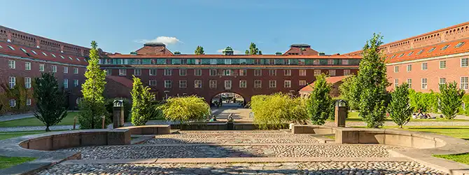 Building with surrounding square and greenery.