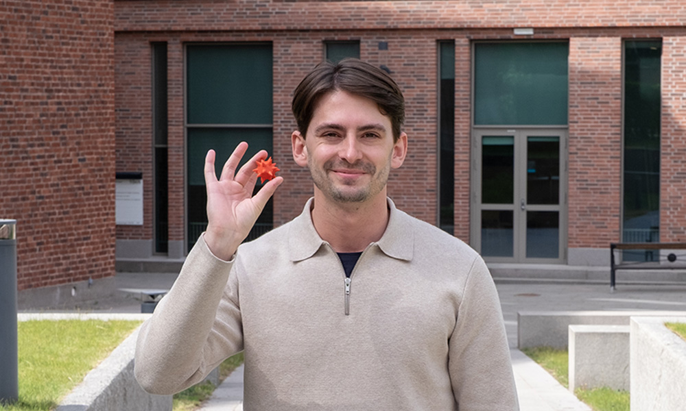 Man outdoors holding a model. 