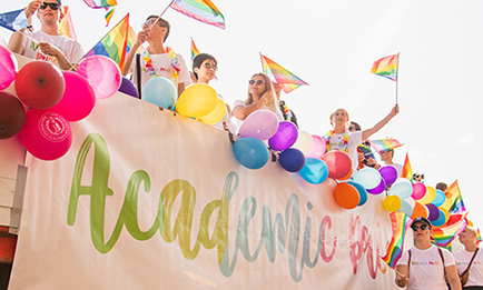 Människor på ett lastbilsflak med ballonger och prideflaggor.
