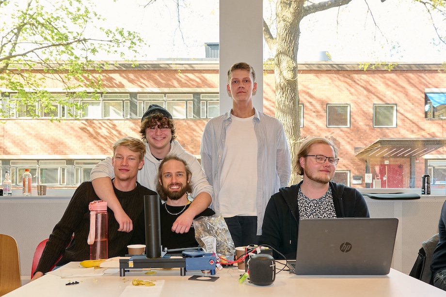 Photo: Five guys standing behind their robot.