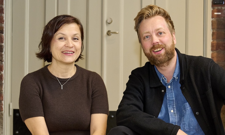 Phto: A woman and a man sitting next to each other smiling towards the camera.