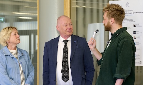 Foto: En kvinn och två män konverserar.