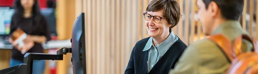 Två personer står bredvid varandra och tittar på en datorskärm.