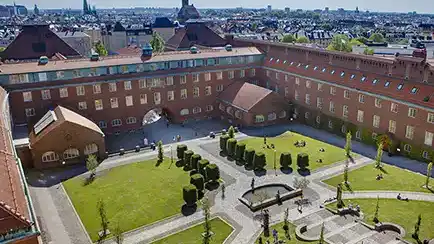 Gård med röda tegelbyggnader runt.