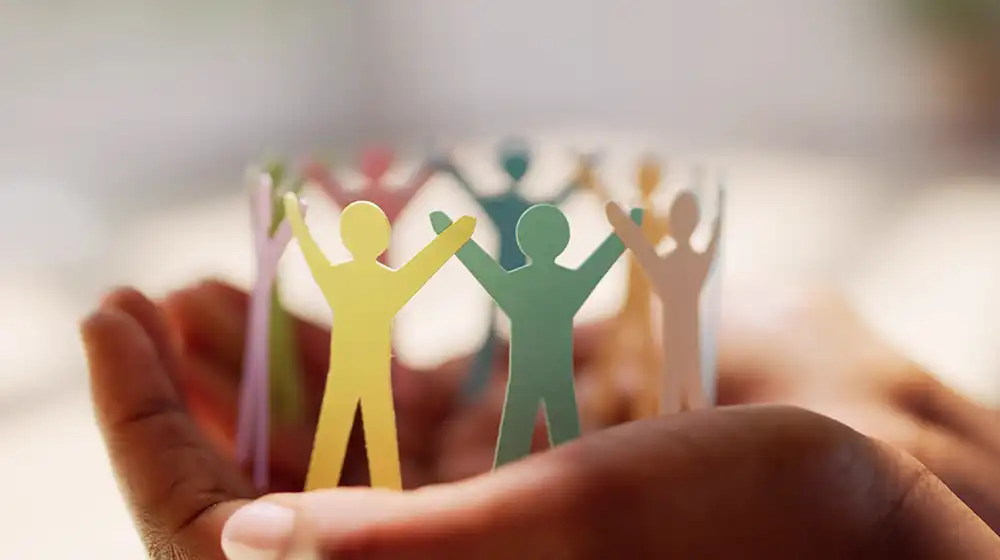 Colorful little men holding hands while standing on one hand.