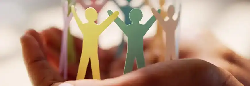 en hand som håller i pappersfigurer