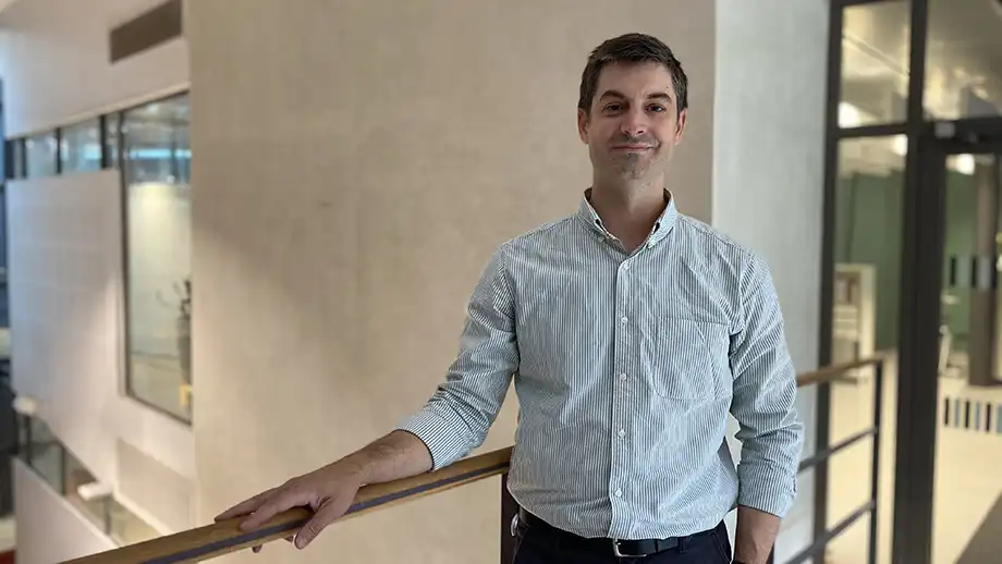 Man in a shirt leaning against a railing.