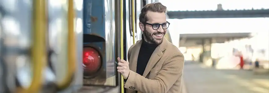 a man in a beige coat embarking a train