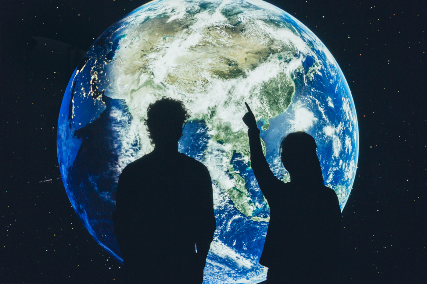 Två människor som betraktar jordklotet 