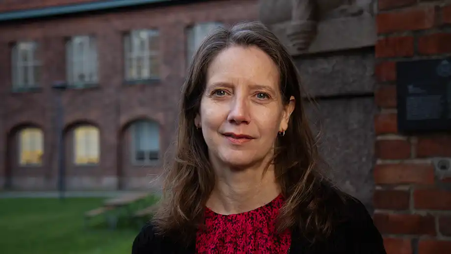 Woman in front of a brick building.