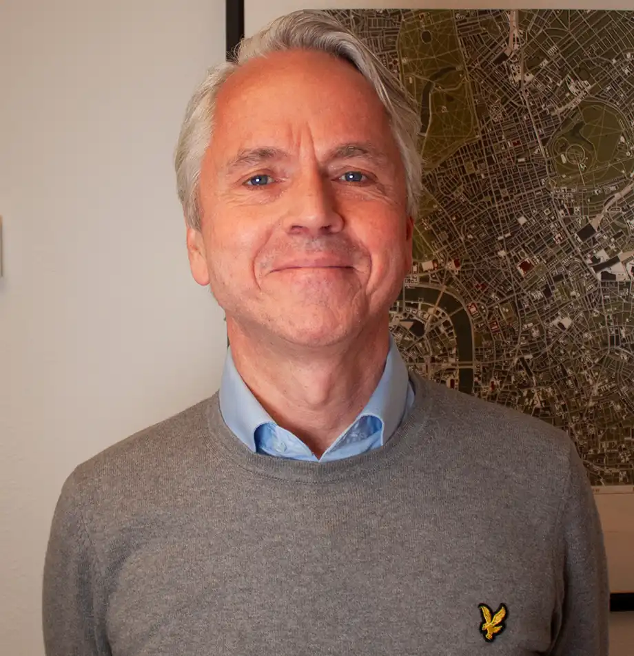 A man in a blue shirt and a grey sweater